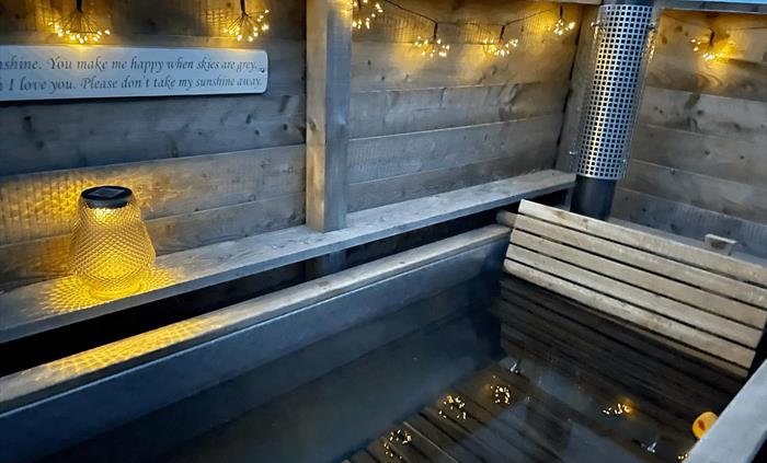 Hot tub at night with twinkling lights and bath filled complete with rubber duck
